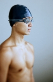 Man in swimming cap and goggles, looking away - Asia Images Group