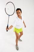 Woman hitting shuttlecock with badminton racket - Asia Images Group
