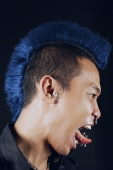 Man with mohawk, side view, mouth open, sticking tongue out - Asia Images Group