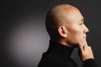 Man with shaved head, hand on chin, profile - Asia Images Group