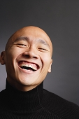 Man with shaved head, laughing - Asia Images Group