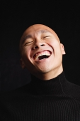 Man with shaved head, laughing, portrait - Asia Images Group