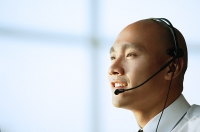 Man with headset, smiling, side view - Asia Images Group