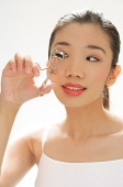 Woman using eyelash curler - Asia Images Group