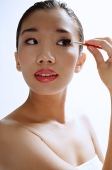 Woman applying eye shadow - Asia Images Group