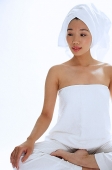 Woman sitting cross legged, wearing towel on head - Asia Images Group