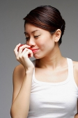 Woman holding apple, to her nose - Asia Images Group