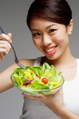 Woman holding bowl of salad - Asia Images Group