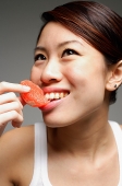 Woman eating orange slice - Asia Images Group