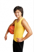 Man with basketball under arm, hand on hip, looking at camera - Asia Images Group