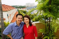 Couple standing on balcony, smiling at camera - Asia Images Group