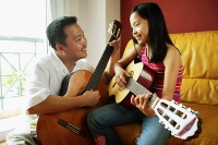 Father and daughter holding guitars - Asia Images Group