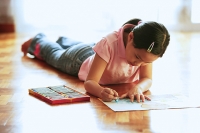 Girl lying on floor, drawing - Asia Images Group