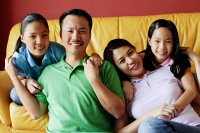 Family of four smiling at camera - Asia Images Group