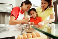 Mother and two daughters in kitchen - Asia Images Group