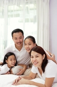 Family of four in smiling at camera - Asia Images Group