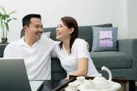 Couple in living room, laughing - Asia Images Group