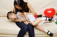 Mother tickling daughter - Asia Images Group