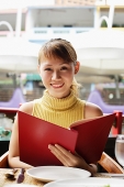 Woman in cafe, holding menu, looking at camera - Asia Images Group