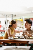 Couple dining in cafe, drinks in hand - Asia Images Group