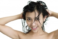 Woman washing her hair, looking at camera - Asia Images Group
