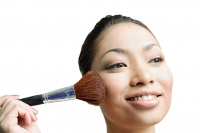 Woman applying blusher with make-up brush - Asia Images Group