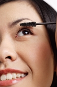 Woman applying mascara, close-up of face - Asia Images Group