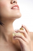 Woman applying perfume - Asia Images Group