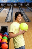 Man with bowling ball, looking at camera - Asia Images Group