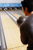 Man bowling, over the shoulder view - Asia Images Group