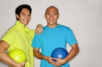 Two men holding bowling balls, smiling at camera - Asia Images Group