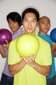 Three men standing carrying bowling balls, looking at camera - Asia Images Group