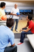 Four men in bowling alley - Asia Images Group