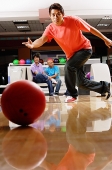 Man bowling, people sitting in the background - Asia Images Group