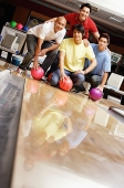 Four men in bowling alley, looking at camera - Asia Images Group