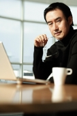 Man using laptop, looking at camera - Asia Images Group