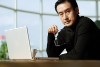 Man with laptop, looking at camera, portrait - Asia Images Group
