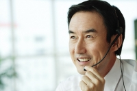 Businessman wearing headset - Asia Images Group