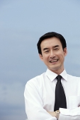 Businessman with arms crossed, smiling at camera - Asia Images Group