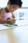 Young girl looking down, drawing with crayons - Asia Images Group