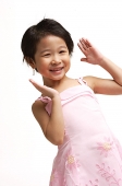Young girl in pink dress, smiling at camera, hands up - Asia Images Group