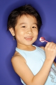 Young girl holding lollypop, smiling - Asia Images Group