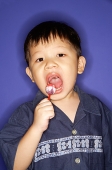 Young boy eating lollypop - Asia Images Group