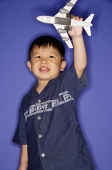 Young boy playing with toy airplane - Asia Images Group