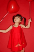Girl holding heart shaped balloon - Asia Images Group