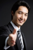 Businessman, looking at camera, offering hand - Asia Images Group