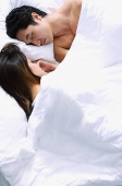 Couple sleeping side by side on bed - Asia Images Group