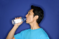 Man drinking water from disposable bottle - Asia Images Group