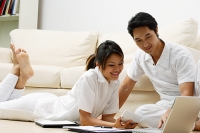 Couple at home looking at laptop - Asia Images Group