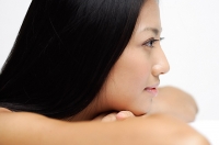 Woman resting head on arms, looking away, side view - Asia Images Group